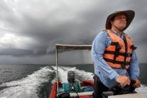 Dr. Benjamin LaBrot in a boat running from a storm, en route to see patients.