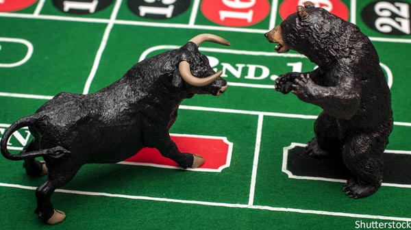 Bull and bear figures square off on a poker table.